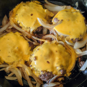 Cast Iron Skillet Burgers with melted cheese and caramelized onions
