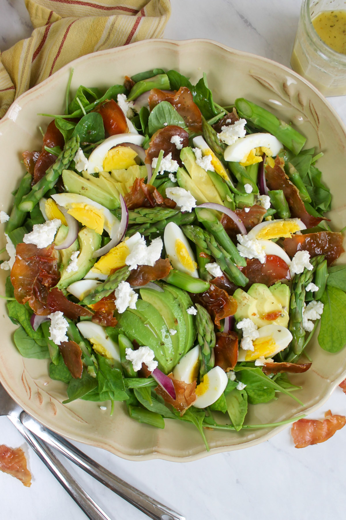 A large platter of Asparagus Salad with crispy prosciutto, hard boiled eggs and avocado.