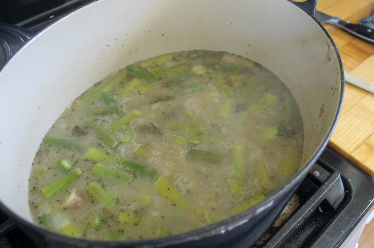 Asparagus soup simmering on the stovetop before it is blended.