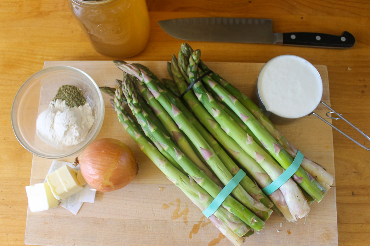 Ingredients on a cutting board for asparagus soup.