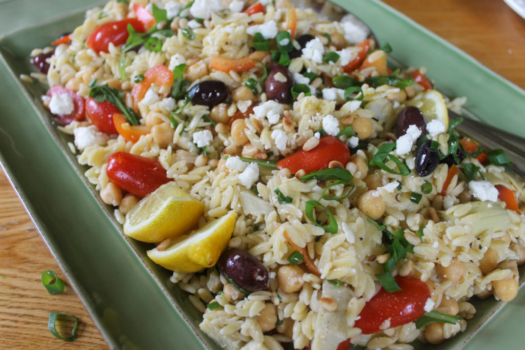 Platter of healthy colorful rainbow orzo salad.