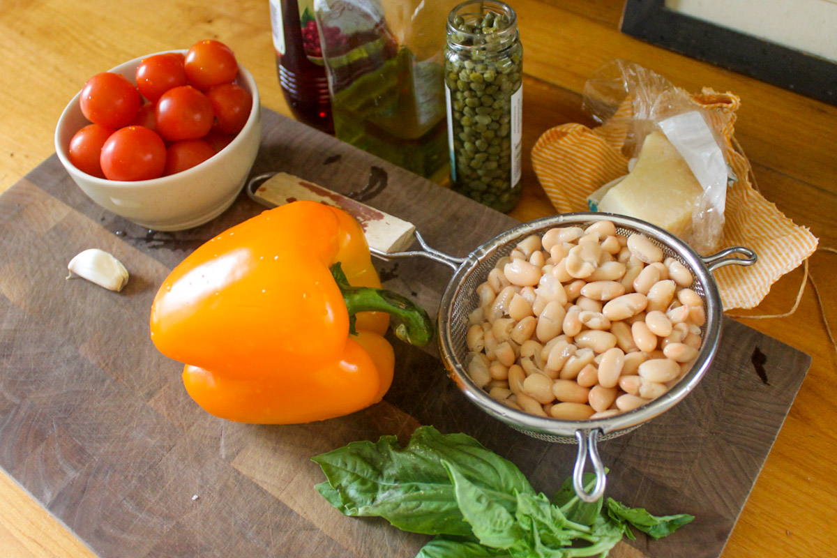 White bean bruschetta ingredients on a cutting board.