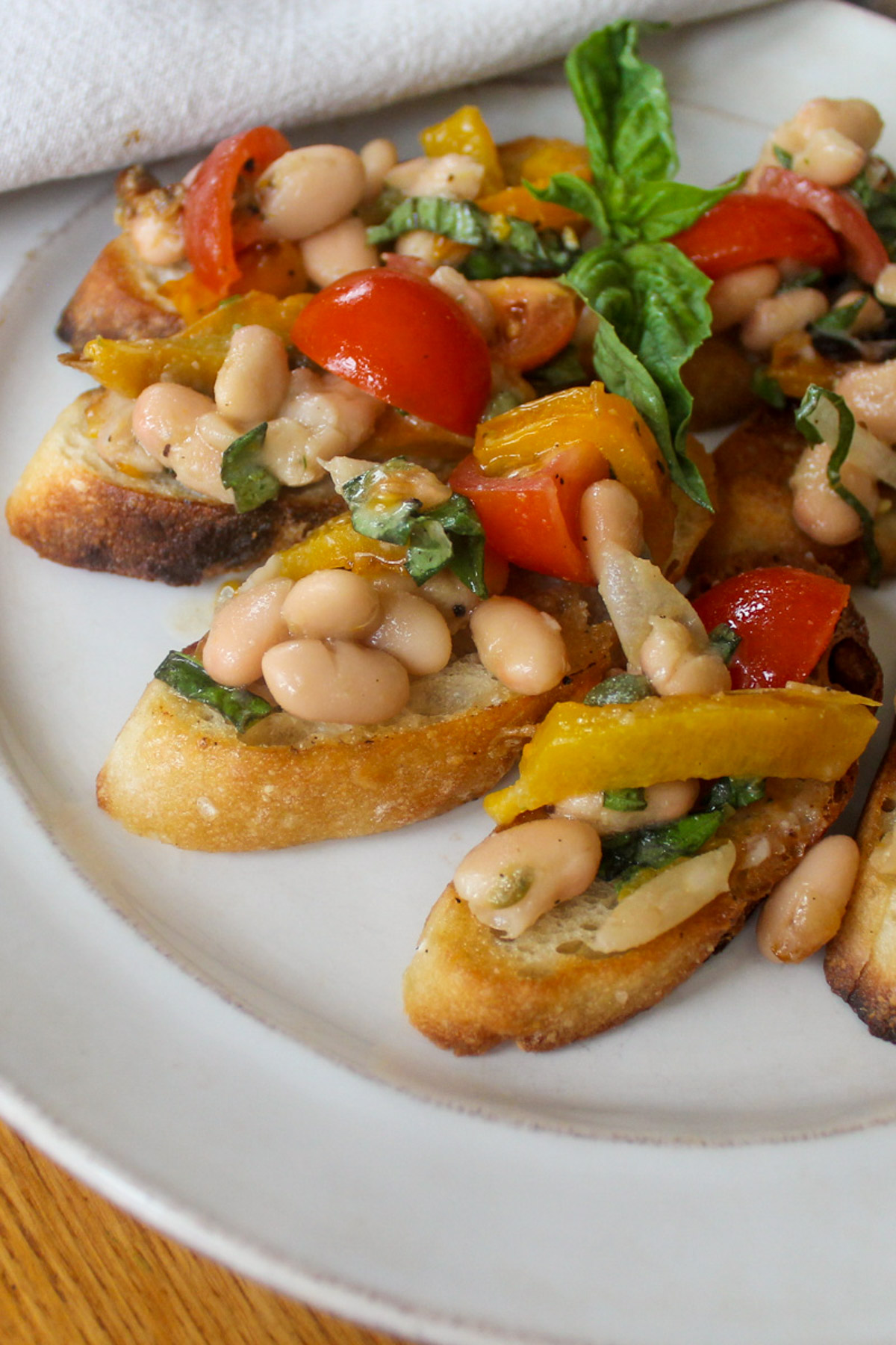 A plate of white bean and roasted garlic bruschetta on toasted crostini.