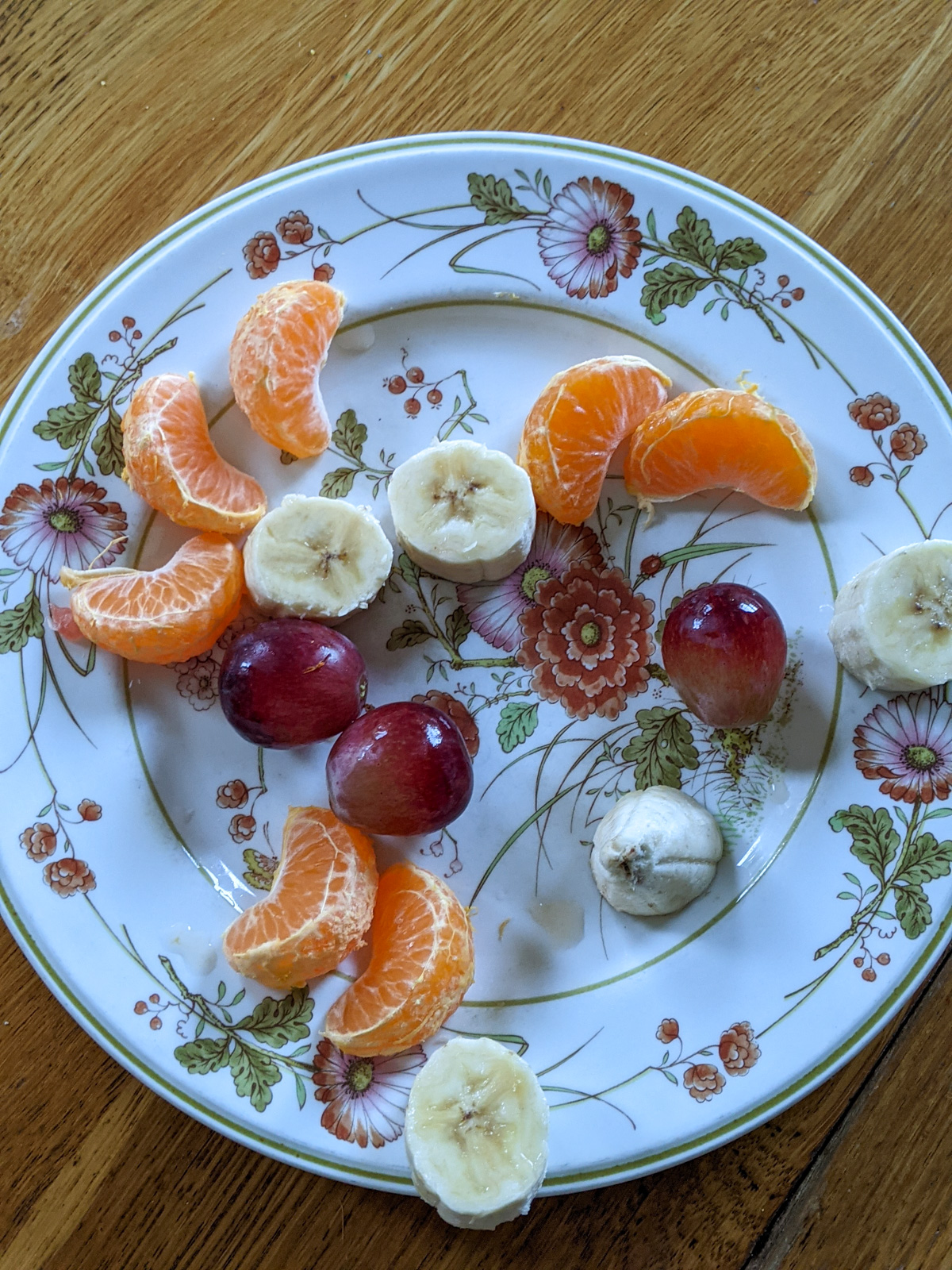 A plate of a few bites of leftover fruit from a kids snack that will go into the freezer for smoothies.