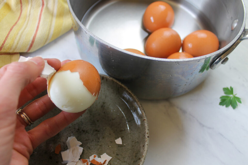 Peeling hard boiled eggs for egg salad.