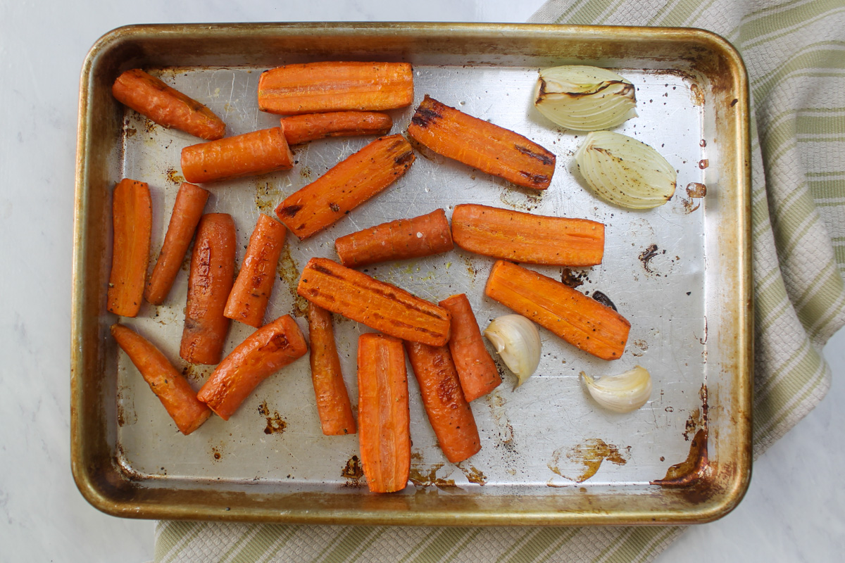 Pan of roasted carrot, onion, garlic ready to make hummus.