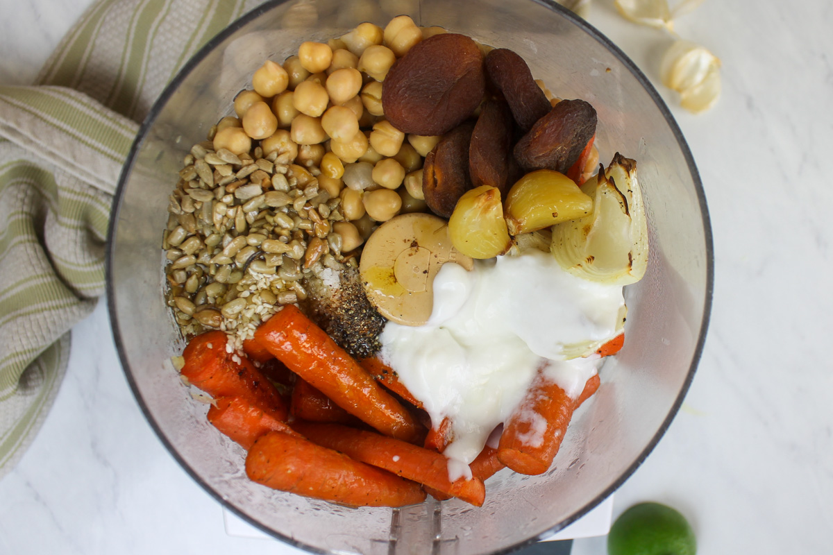 Roasted carrot hummus ingredients ready to process in a food processor.