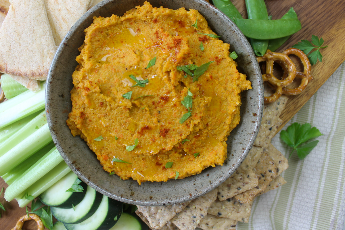 Healthy snack board with roasted carrot hummus.