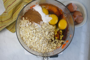 All ingredients added to the bowl of a food processor with the pureed banana and carrot.