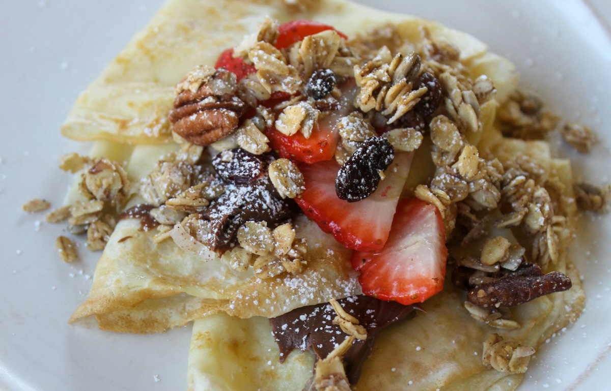 Crepes topped with Nutella, sliced strawberries and homemade granola.