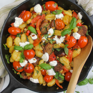 The finished gnocchi dish served in the cast iron skillet and garnished with basil and goat cheese.