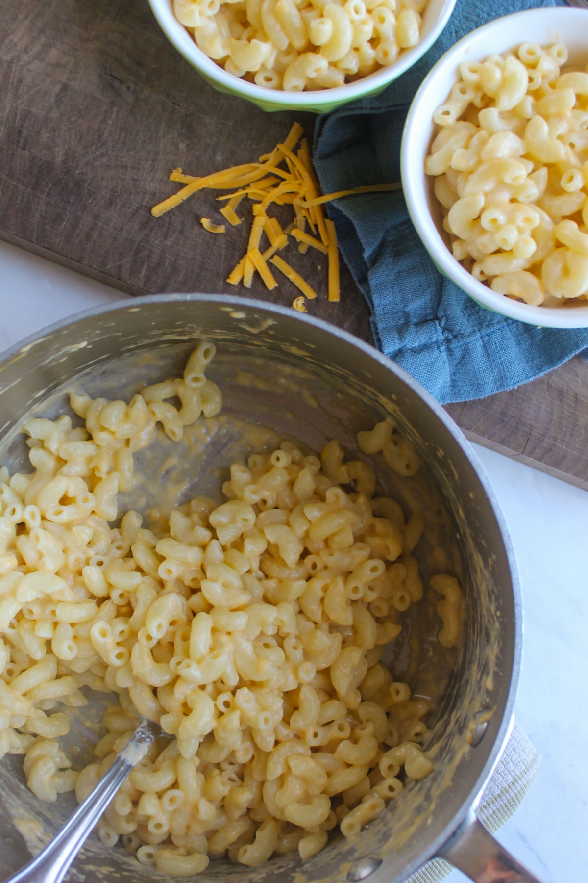 A pot and 2 kid sized bowls of quick mac and cheese.