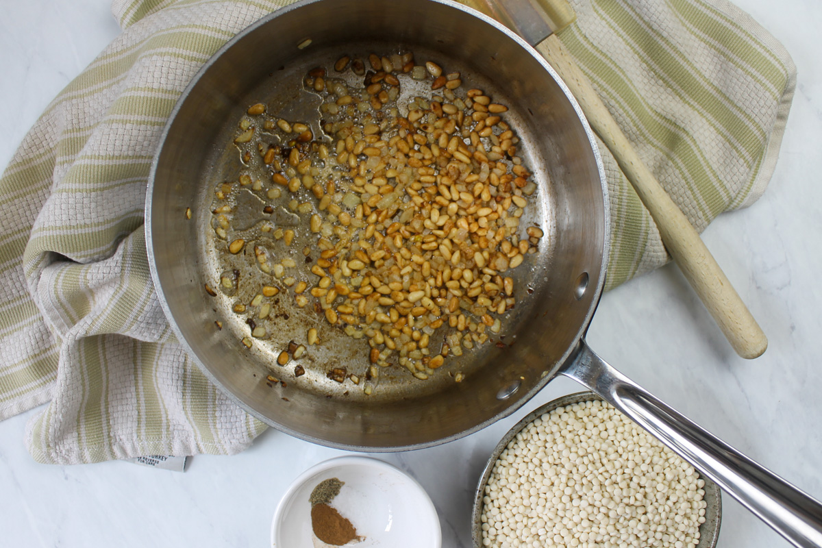 Toasting pine nuts and onions in butter for couscous.