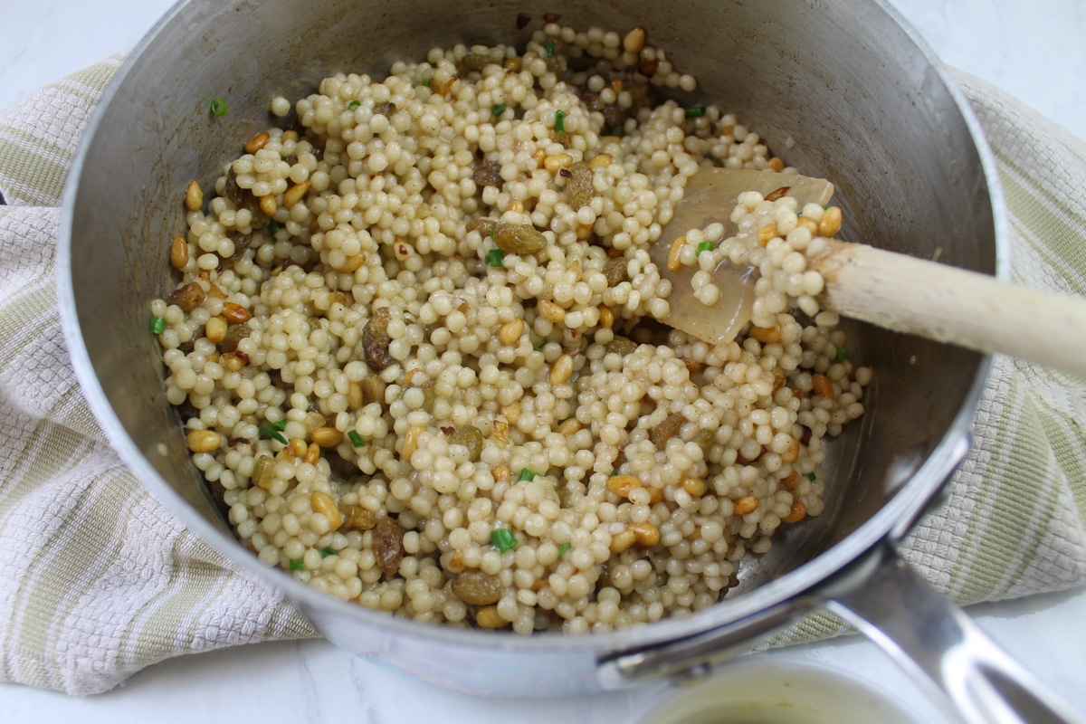 The finished pot of cooked couscous mixed with pine nuts and golden raisins and a hint of cinnamon.