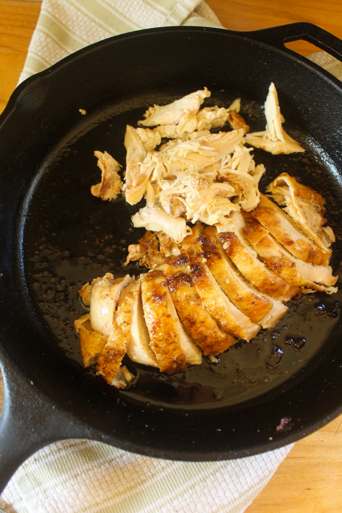 A cast iron skillet with sliced chicken breast ready to use.