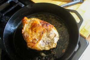 The finished chicken breast cooked in a cast iron skillet.