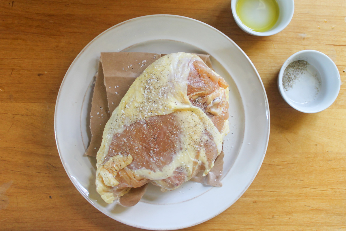 Raw chicken breast seasoned with salt and pepper.