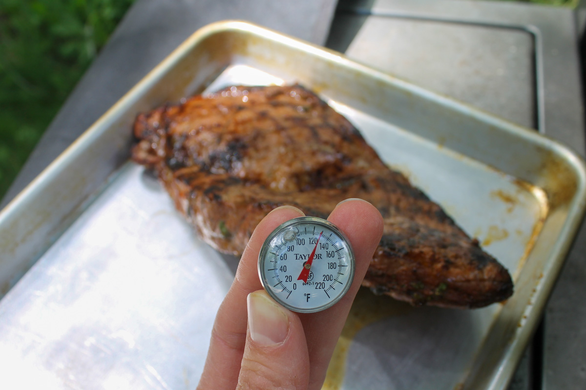 A thermometer checking the internal temperature of the steak, 130 degrees for medium rare.