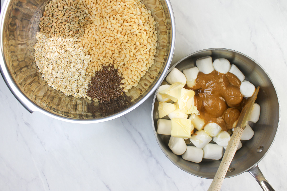 A bowl of rice krispies and dry ingredients and a pot of marshmallow, peanut butter ready to melt.