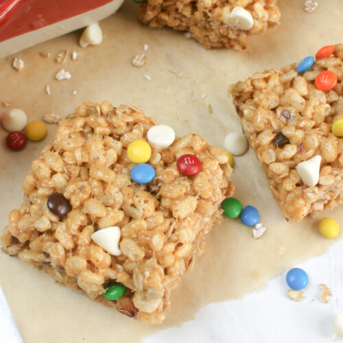 A peanut butter rice krispie treat bar topped with m&m's and white chocolate chips.