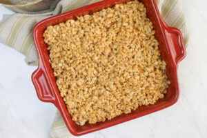 A red square pan with peanut butter protein rice crispy treats.