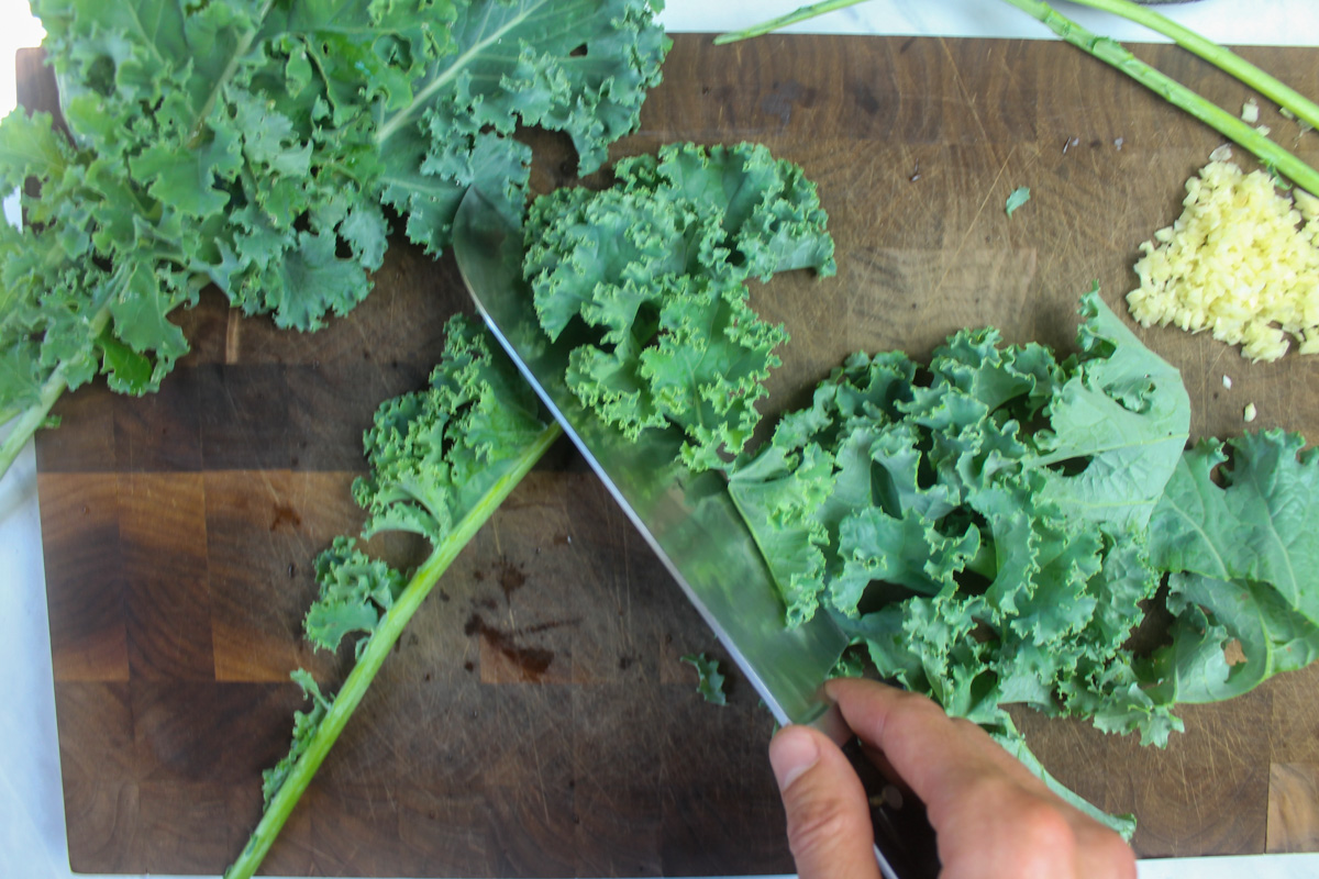 Slicing kale leaves off the stem.