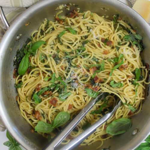 Kale bacon pasta with spaghetti noodles and fresh basil.