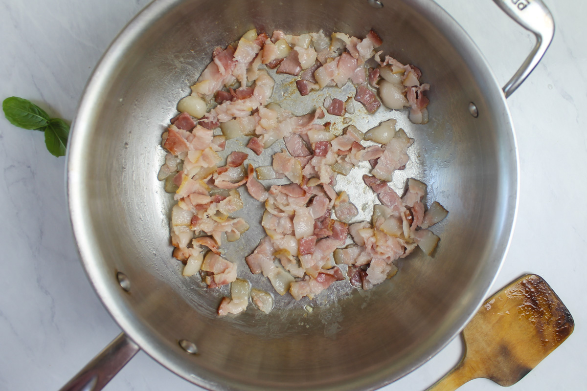 Bacon beginning to saute for kale basil bacon pasta.
