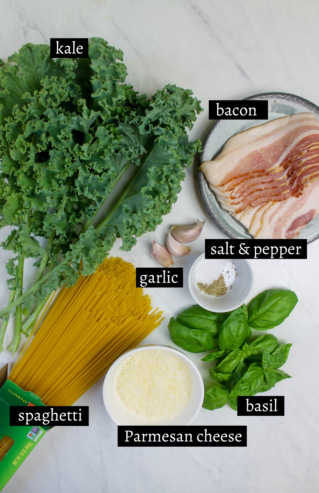 Labeled ingredients for bacon kale spaghetti with Parmesan cheese and basil.