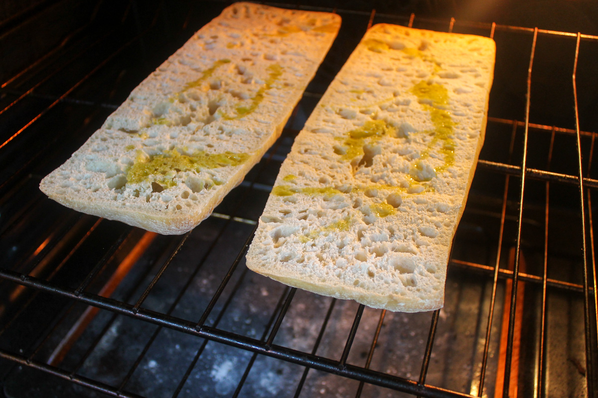 Baking the ciabatta bread, sliced open, in the oven.