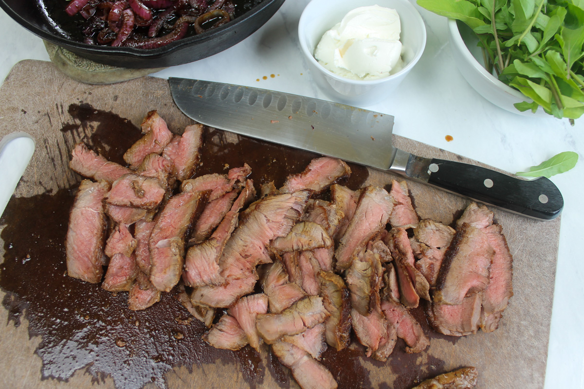 Thinly sliced medium rare steak for sandwiches.