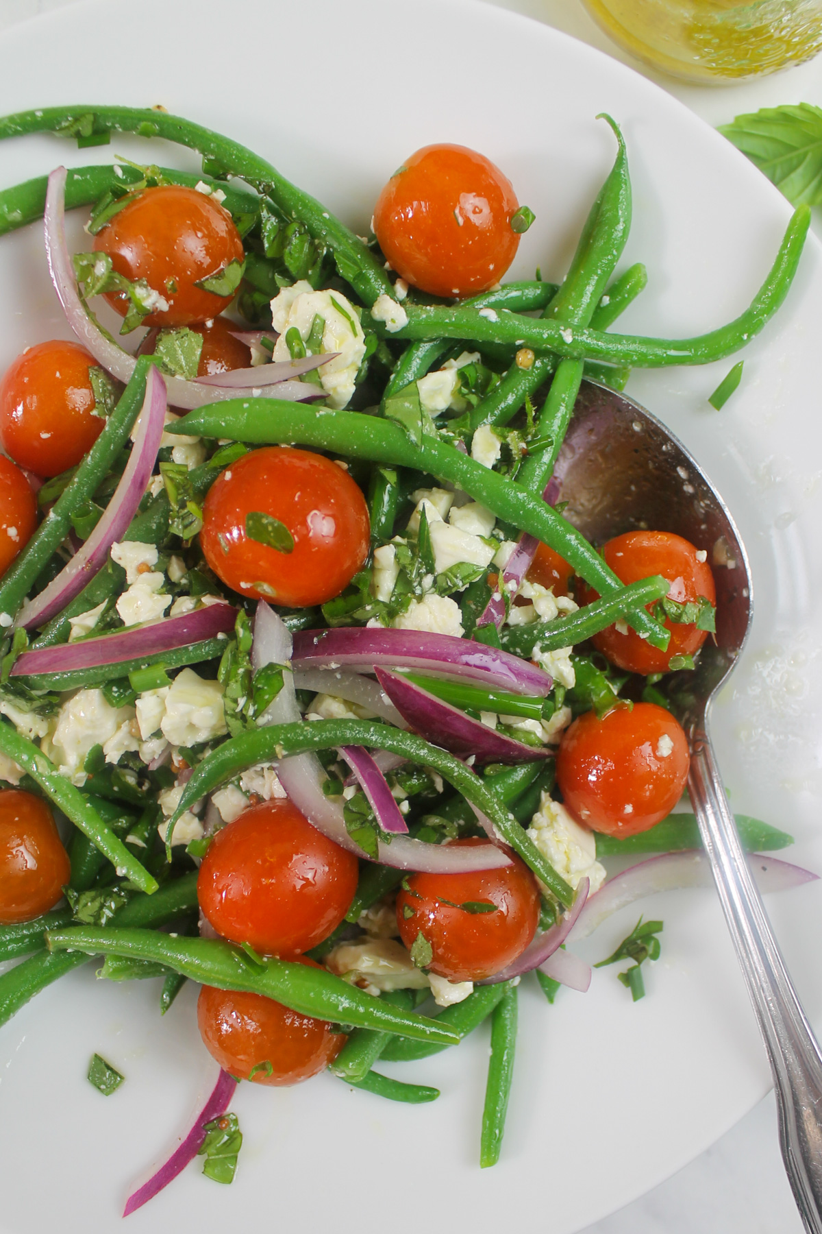 A summer green bean salad with fresh herbs, feta cheese and cherry tomatoes.