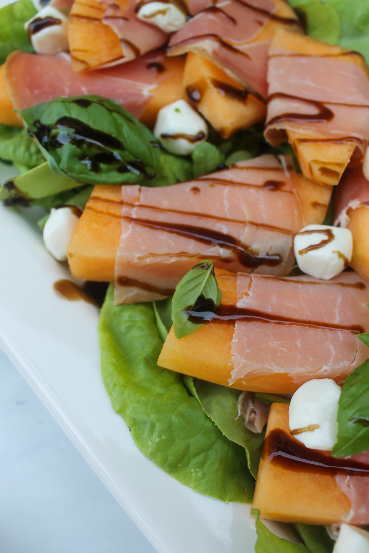 Melon and prosciutto salad with drizzled balsamic glaze.