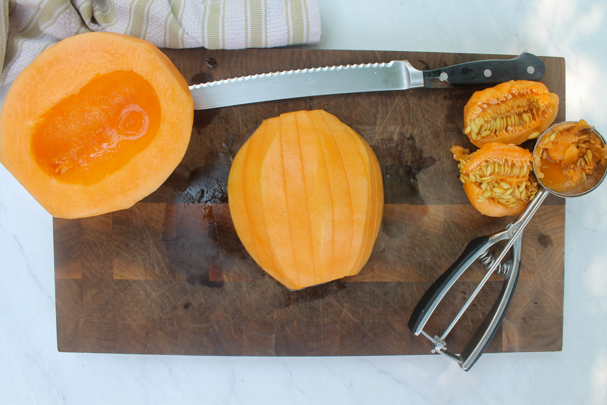 Melon sliced to wrap with prosciutto.