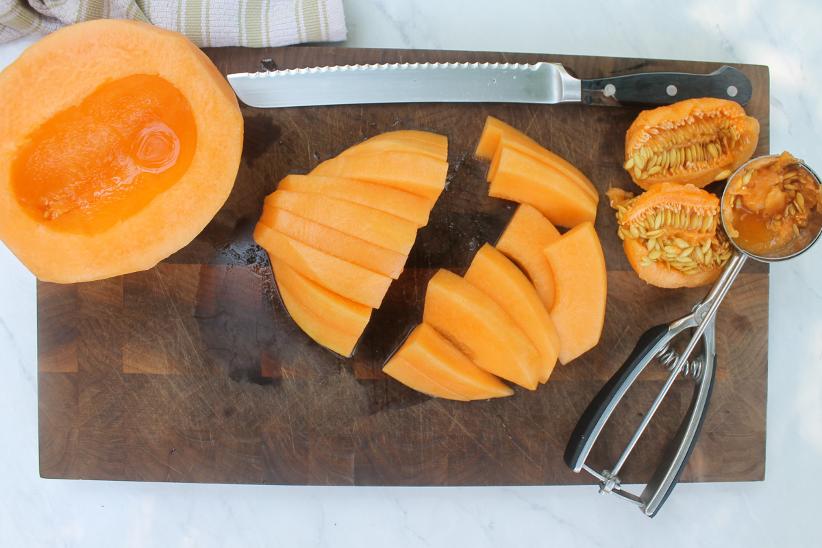 Slice melon cut to be wrapped in prosciutto.