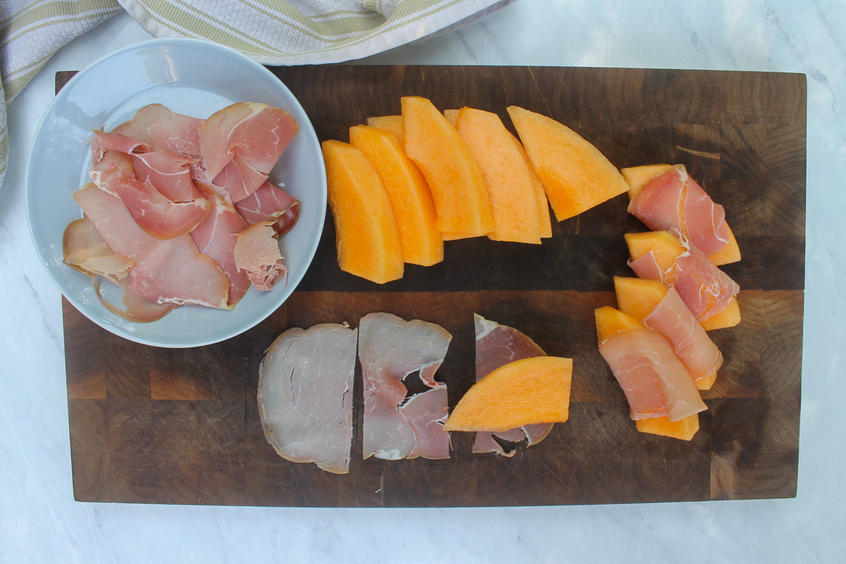 Wrapping each melon slice with thin prosciutto for salad.