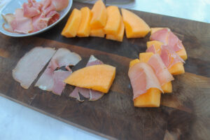 Wrapping each melon slice with thin prosciutto for salad.