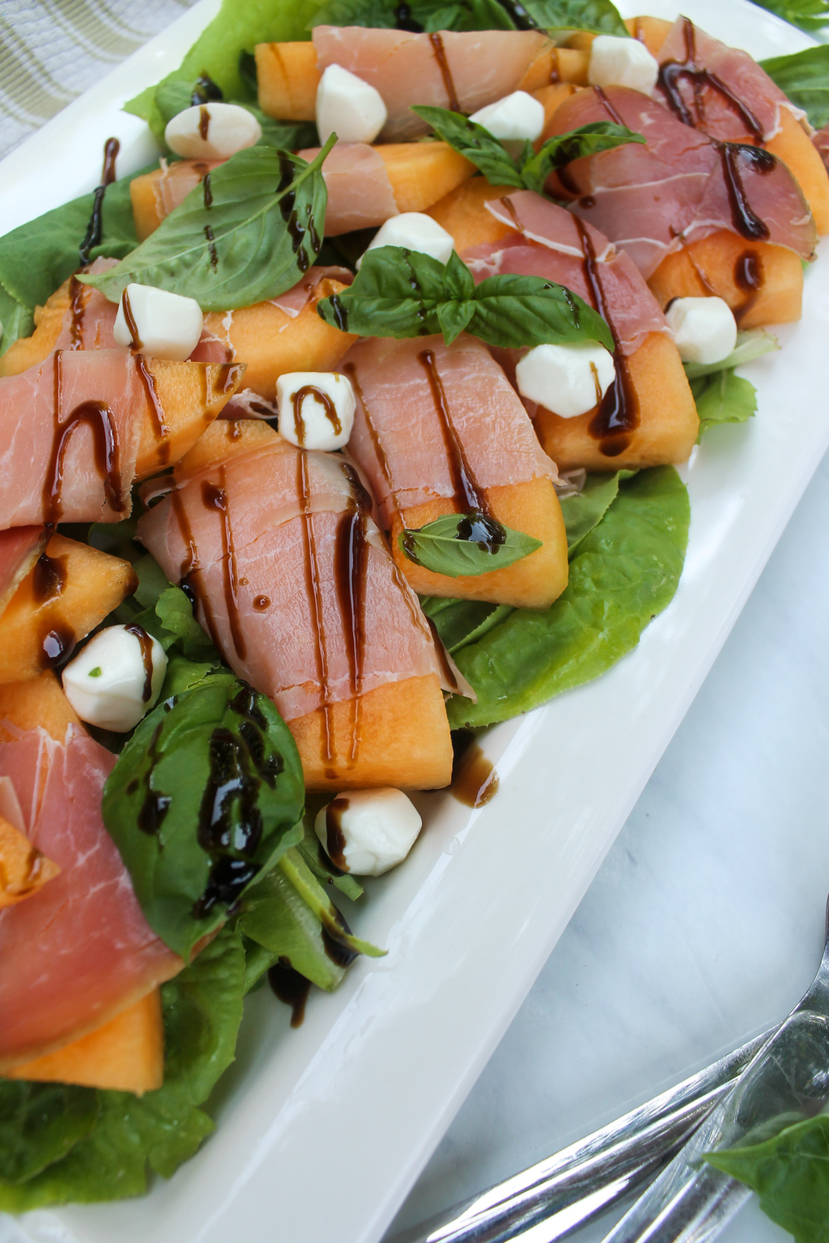 Melon wrapped in prosciutto arugula salad with mozzarella.