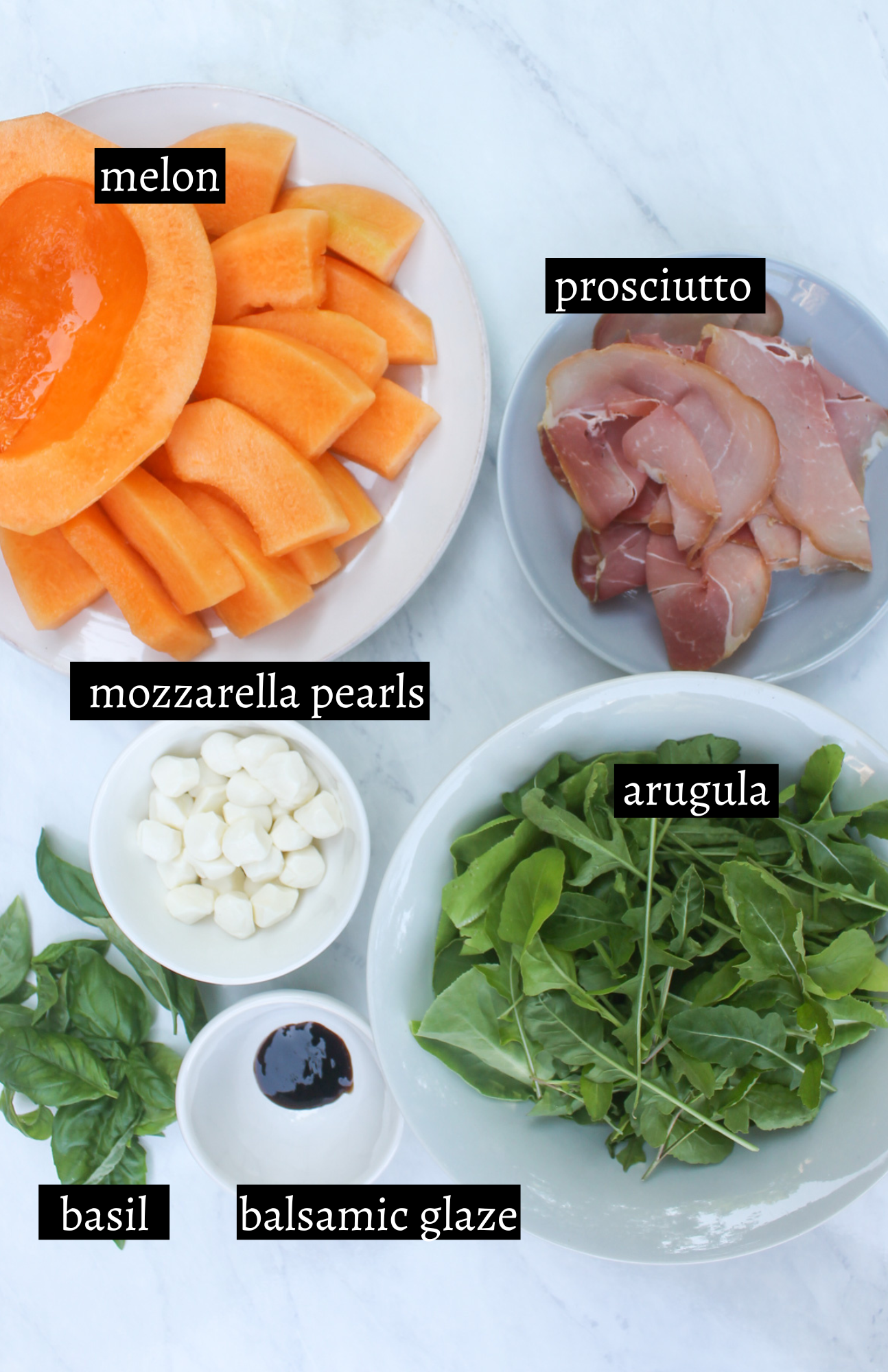 Labeled ingredients for melon prosciutto salad with mozzarella and basil.