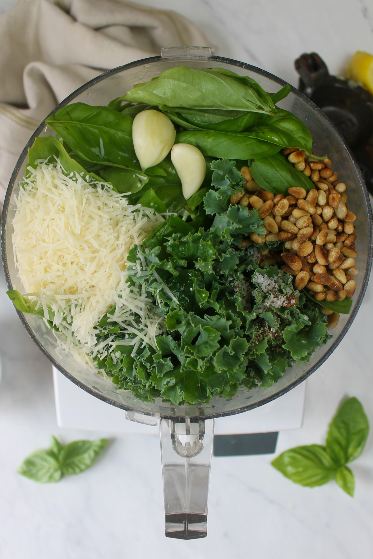 Pesto ingredients in the food processor ready to puree.