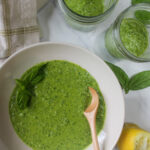 A bowl of basil kale pesto and extra jars to freeze.