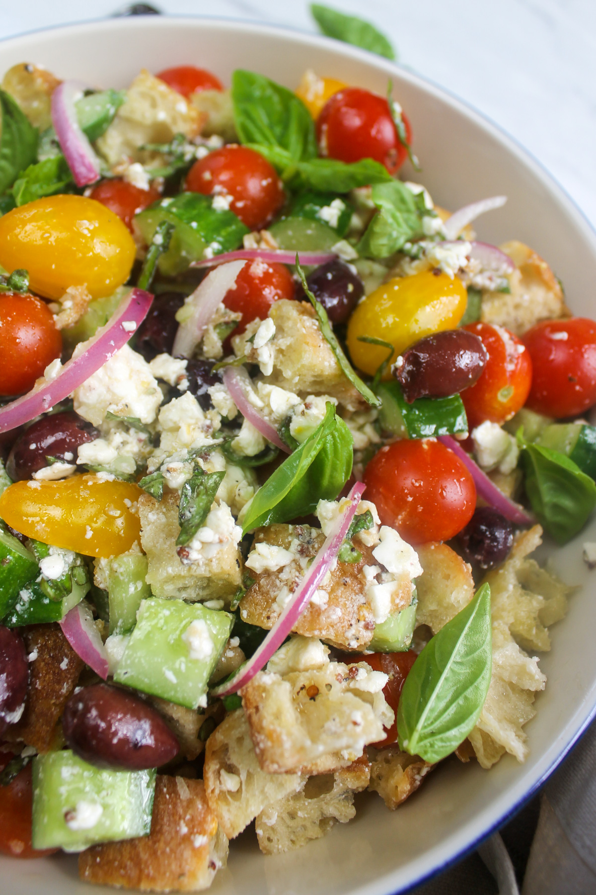 Healthy bread salad with yellow and red cherry tomatoes, feta and olives.