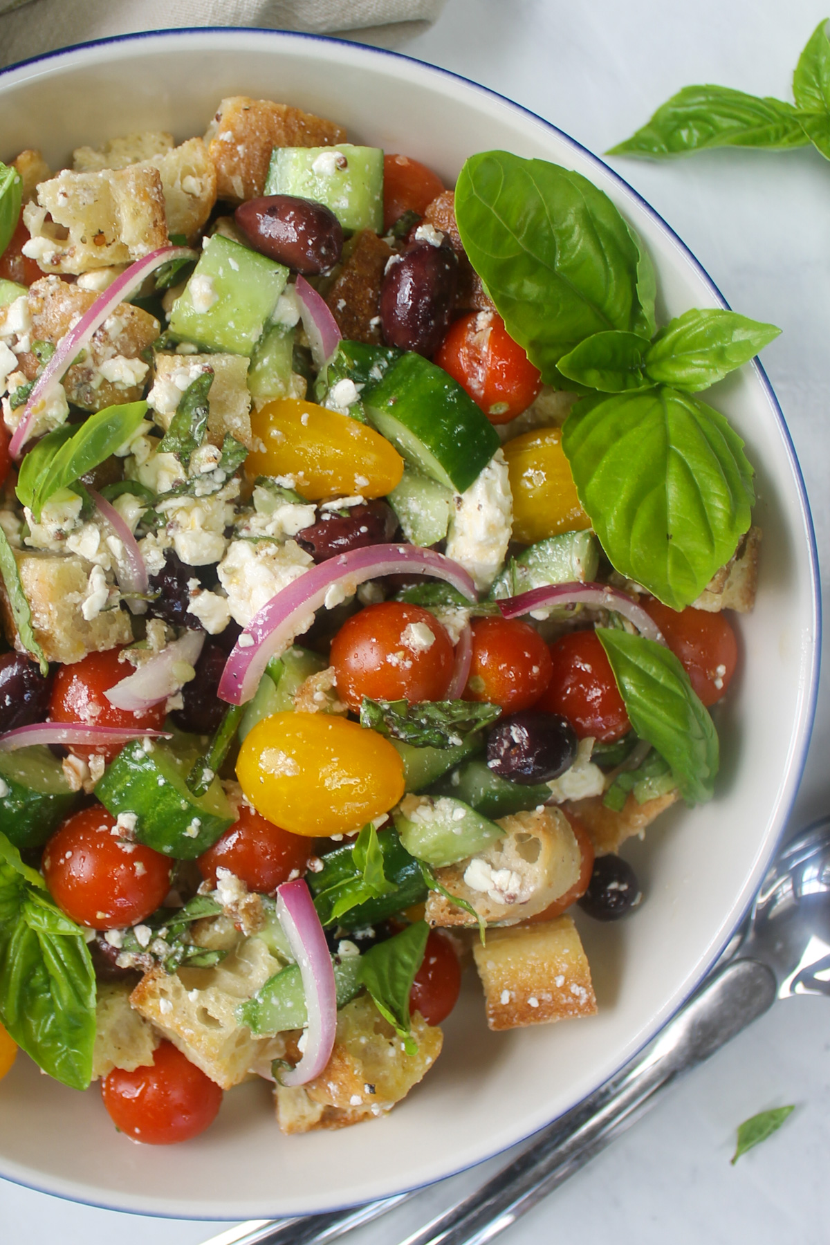 Tomato, cucumber, olive and feta panzanella with fresh basil.