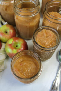 Jars of tan applesauce ready for the freezer.