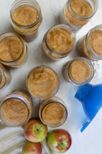 Jars of applesauce filled using a wide-mouth funnel.