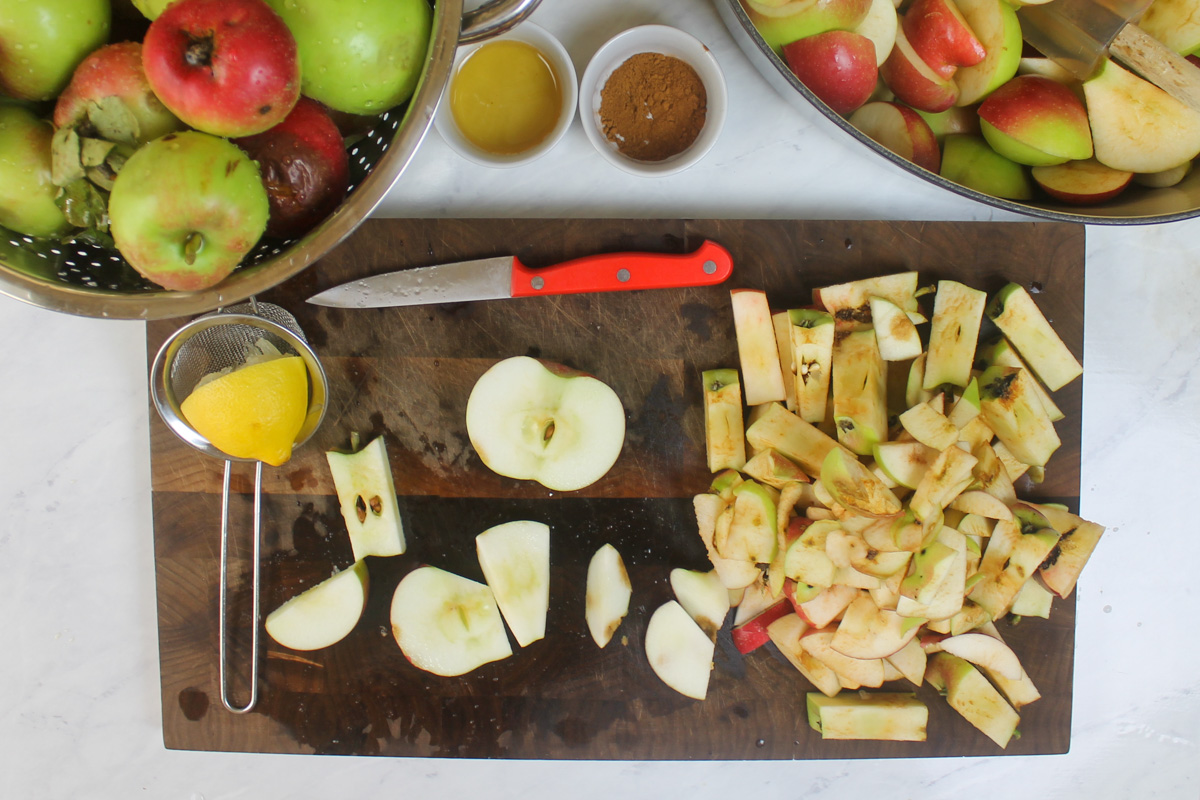 A cutting board chopping apples for applesauce, a pile of apple cores.