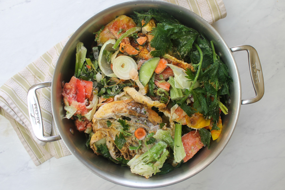 A pot full of chicken bones and vegetable scraps that have been saved and frozen.