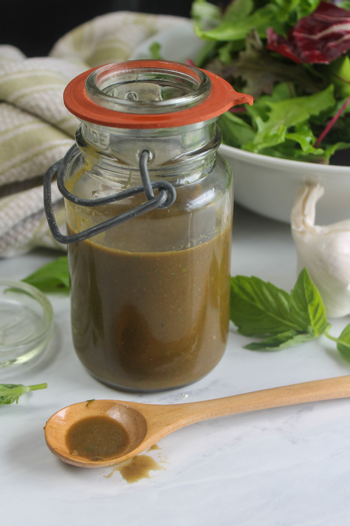 A jar of blended basil garlic balsamic vinaigrette dressing.