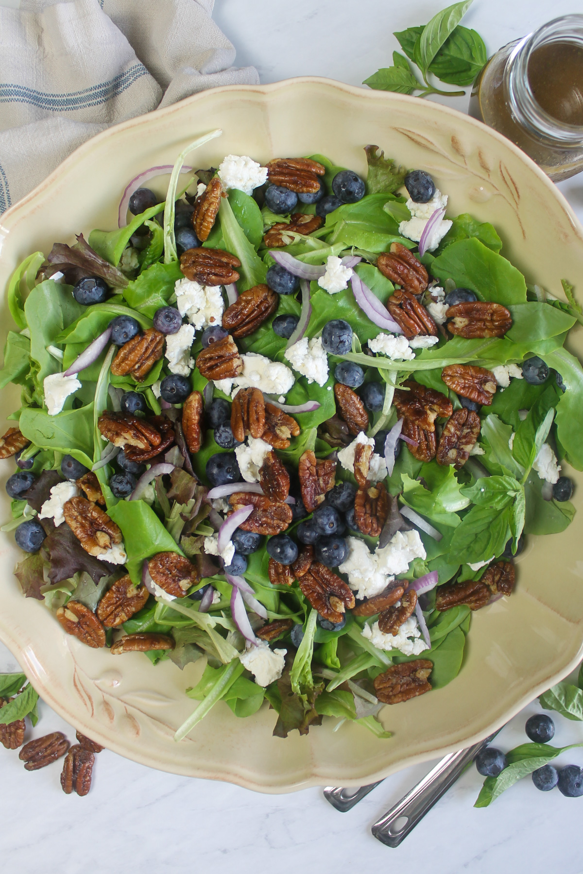 A large platter of blueberry goat cheese salad with candied pecans.