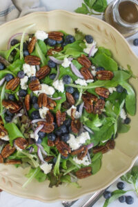 Blueberry goat cheese salad with a jar of basil balsamic vinaigrette.